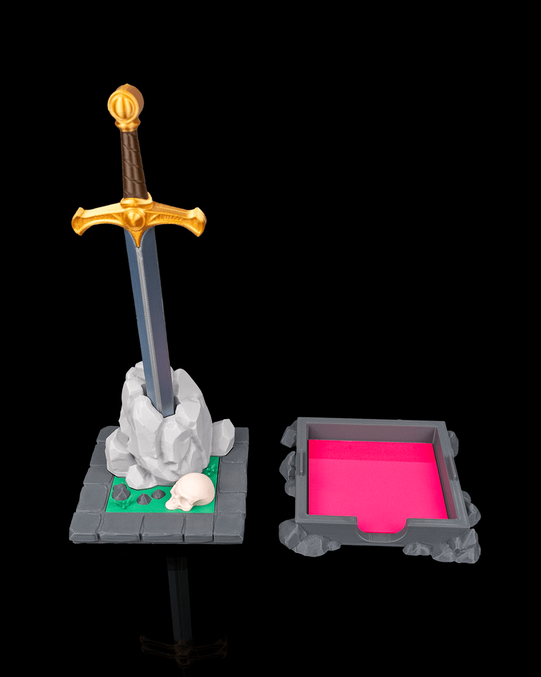 Deskalibur Pen Holder with sword and stone display stands next to a pink sticky note tray.