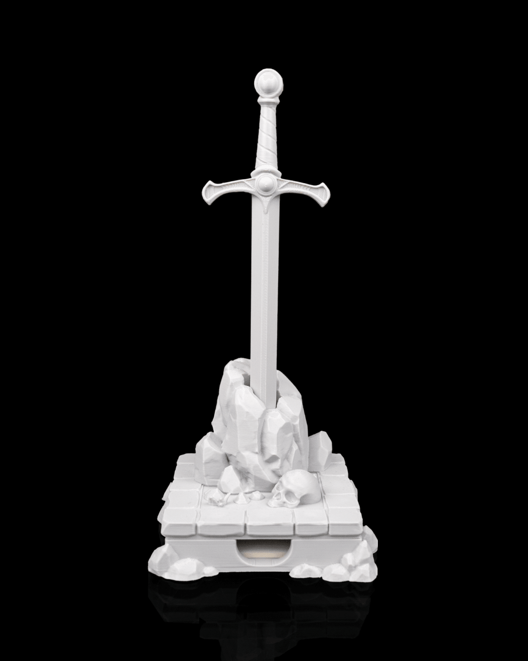 Deskalibur Pen Holder featuring a sword on a rocky base, designed to organize pens and sticky notes on your desk.